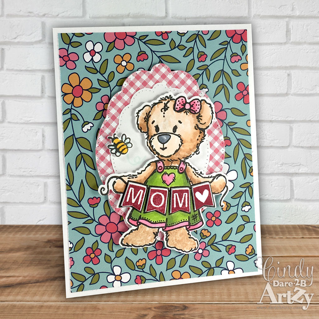 This sweet bear and her banner are ready to brighten up any card or scrapbook page. All the pennant clear stamp sentiments can be stamped directly into the pennant she is holding. By Dare 2B Artzy.