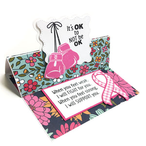 Handmade card using the die, "Wavy Square Fun Fold" from Dare 2B Artzy.  Card include an image of boxing gloves and a cancer ribbon with the quote, "Its ok to not be ok".