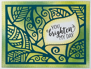 Handmade card with a sentiment that says, "You brighten my day". Uses the background die cut "Leaf Background" and stamp set, "Well Wishes" from Dare 2B Artzy.