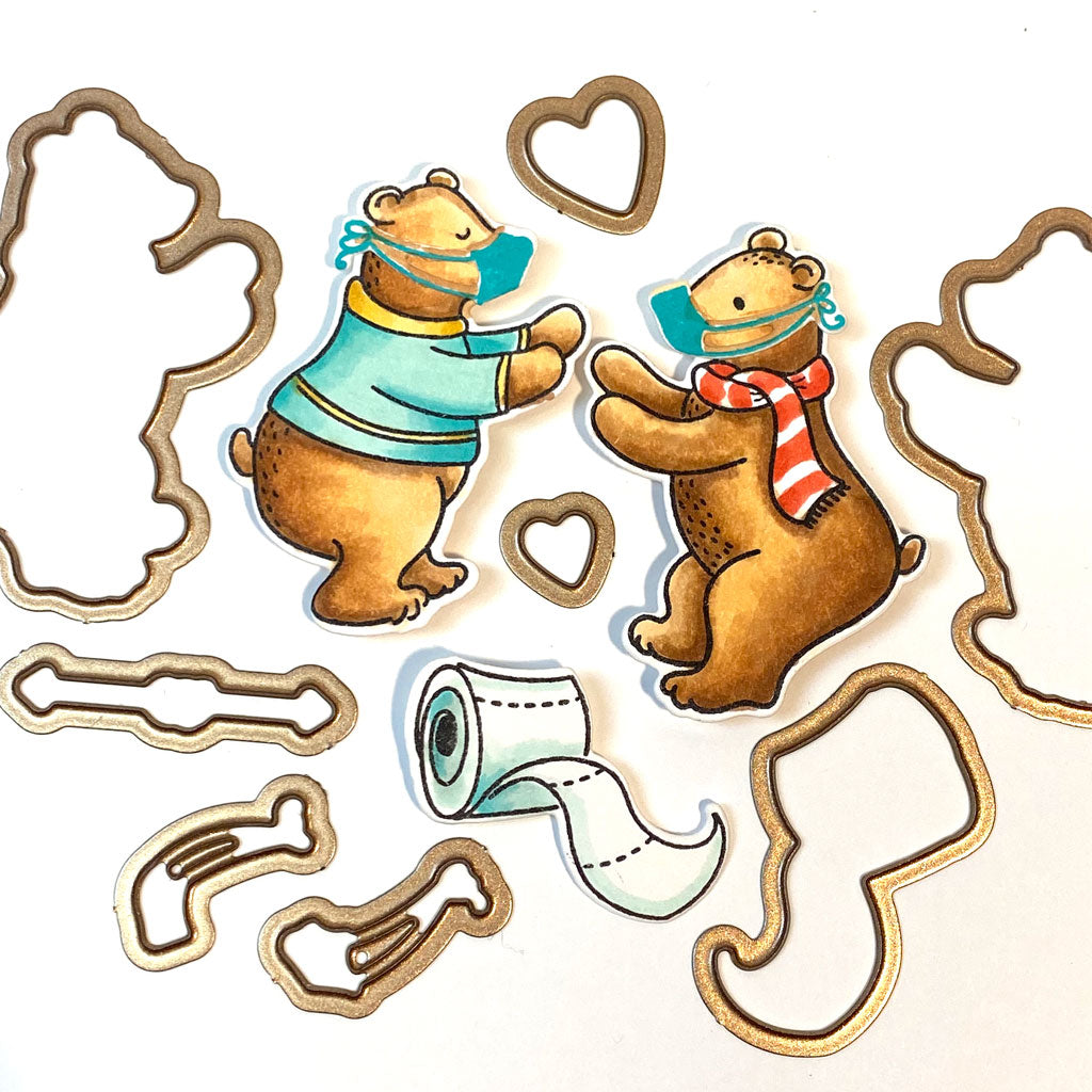 Die cut images of two colored in bears with masks on.  Die cut and stamps are "Bear Hugs" from Dare 2B Artzy.